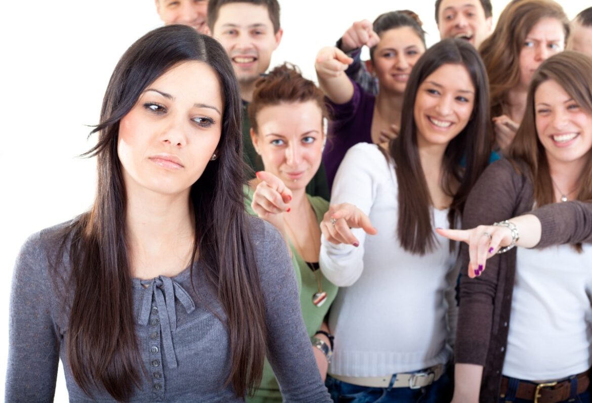 Crowd pointing fingers at a young woman
